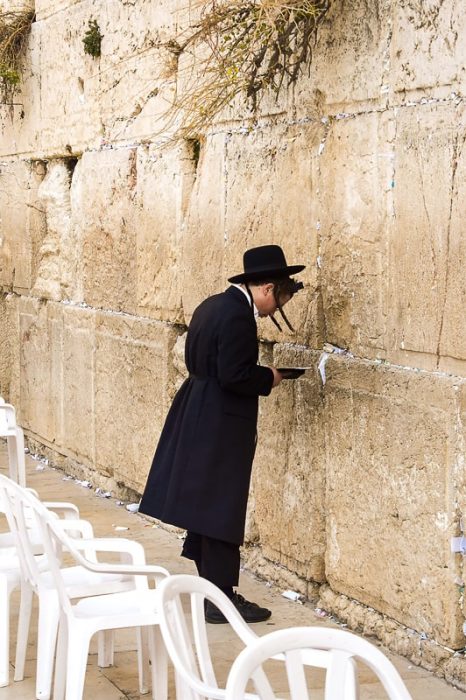 Jud v tradicionalni obleki se naslanja na zid žalovanja