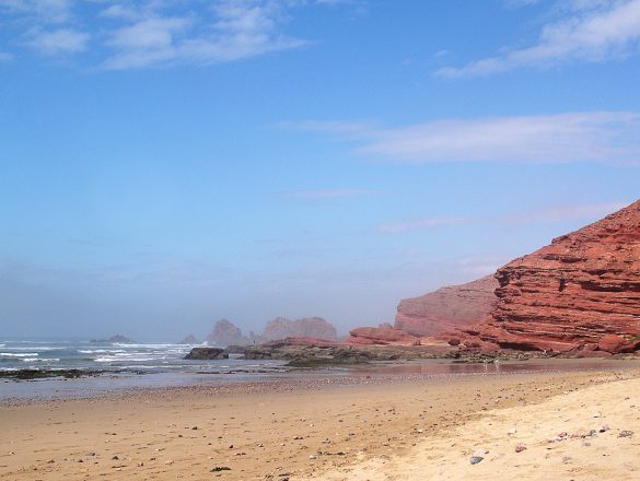 plaža Legiza, Maroko je peščena plaža z rdečimi skalnimi strukturami in naravnimi mostovi