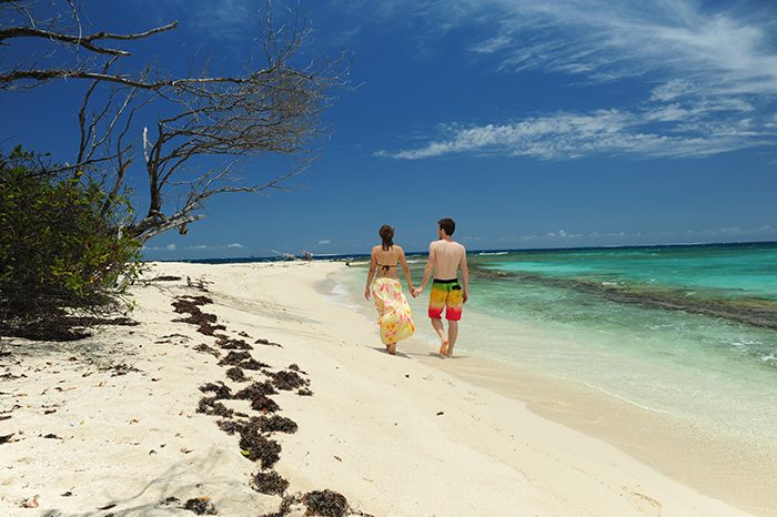 Par, ki se sprehaja po peščeni plaži