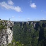moški stoji na vrhu kanjona Serra Geral