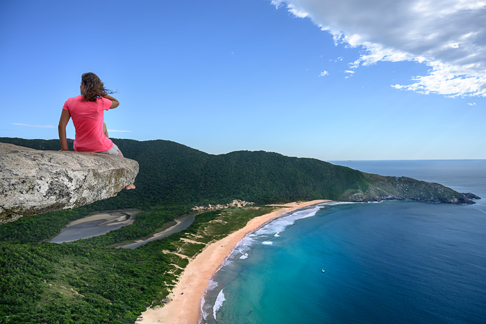 ženska sedi na skali nad plažo Lagoinha de Leste