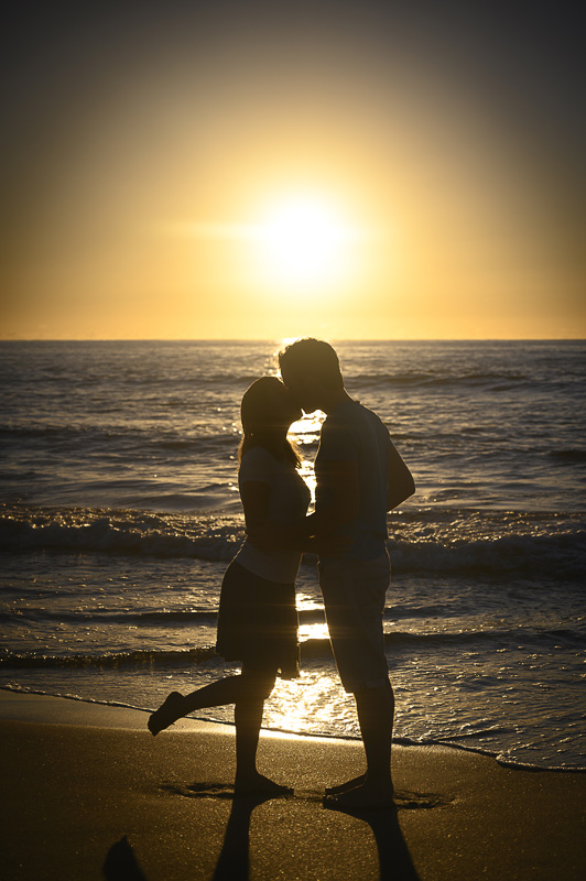 moški in ženska v objemu na plaži. sončni vzhod