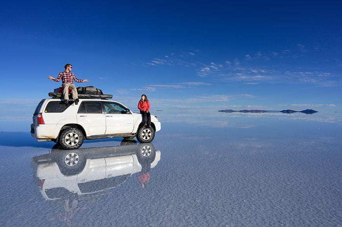 bel terenski avto na vodi. Salar de Uyuni, Bolivija