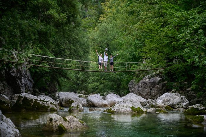 trije ljudje na visečem mostu. Idrija
