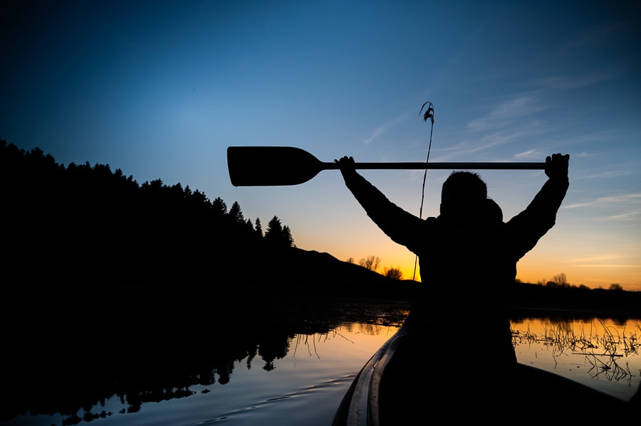 obris ženske v čolnu in z veslom v roki