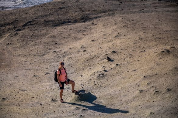 ženska na plaži Cane Malu stoji ob mini vulkančku