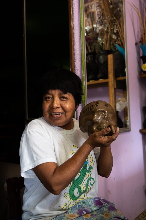 mehiška ženska drži v roki lobanjo iz gline