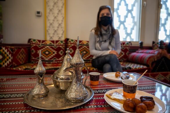 Arabski zajtrk. ženska z masko sedi pri mizi, pripravljeni za arabski zajtrk