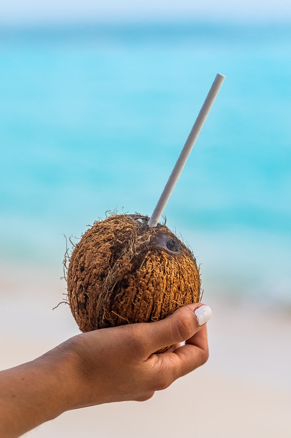 ženska drži v roki kokosov oreh