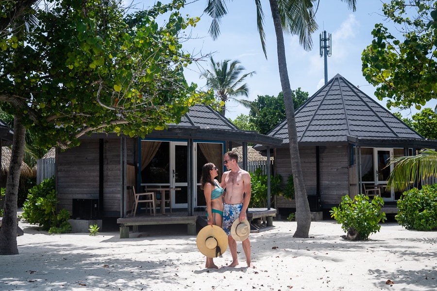 moški in ženska pred hiško na plaži. Kuredu resort na Maldivih