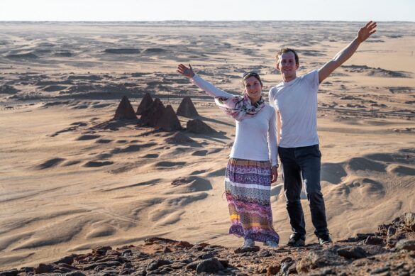 popotnika stojita na gori Jebel Barkal, za njima so sudanske piramide, Karima