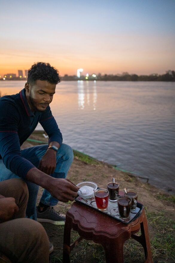 Sudanec pije čaj ob reki Nil