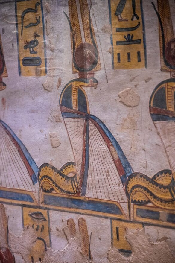 Poslikava kače, oblečene v obleko ter okronane s perjem, rogovi in sončnim diskom. V grobnici Ramsesa III