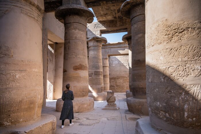 ženska hodi med stebri templja Karnak