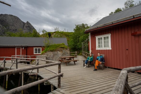 Nusfjord, par sedi pred tipično rdečo leseno ribiško hiško