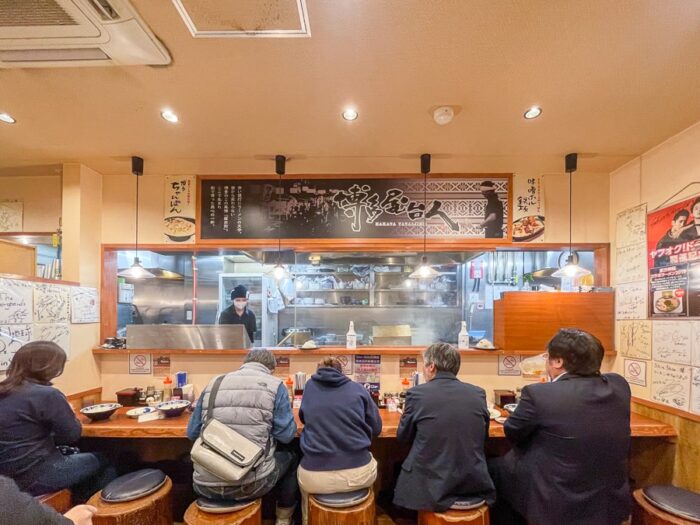 Japonske restavracije. Ljudje sedijo pri skupni mizi